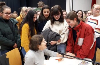 Eva Erben signing book with students