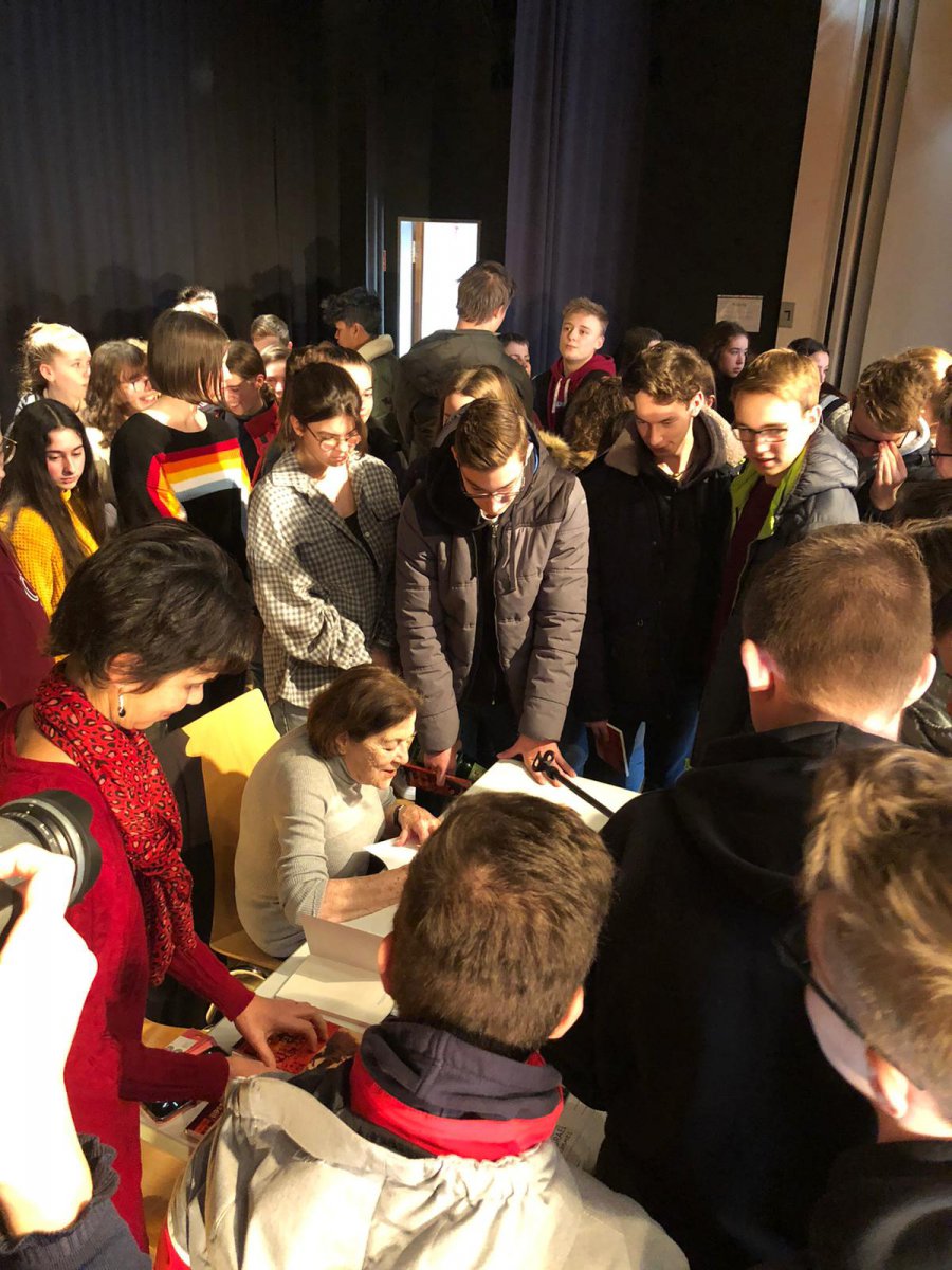 Survivor surrounded by students