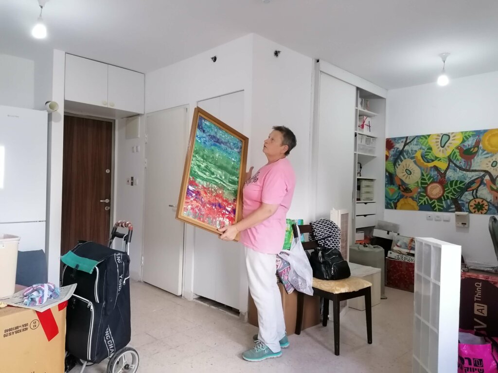 Tanya with her paintings in her new home