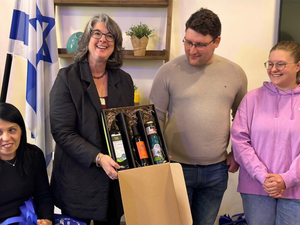 Nicole Yoder handing a gift bag to Dmitri and his wife