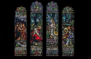 Stained glass windows in the cathedral depicting Jesus, his disciples, and an angel at Gethsemane as the Roman soldiers arrive to arrest him. (Credit: K. Mitch Hodge/Unsplash)