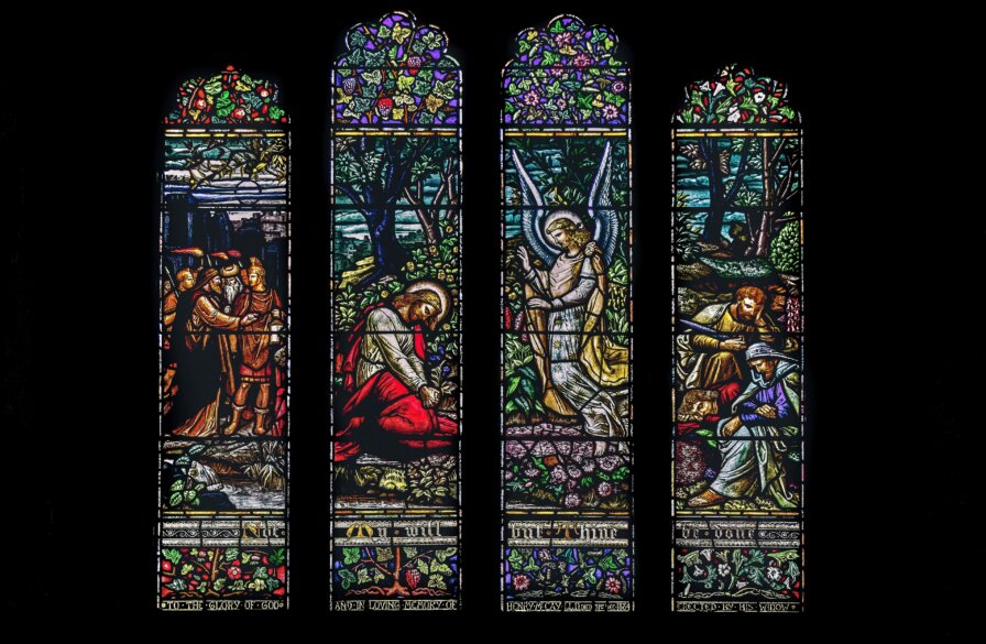 Stained glass windows in the cathedral depicting Jesus, his disciples, and an angel at Gethsemane as the Roman soldiers arrive to arrest him. (Credit: K. Mitch Hodge/Unsplash)