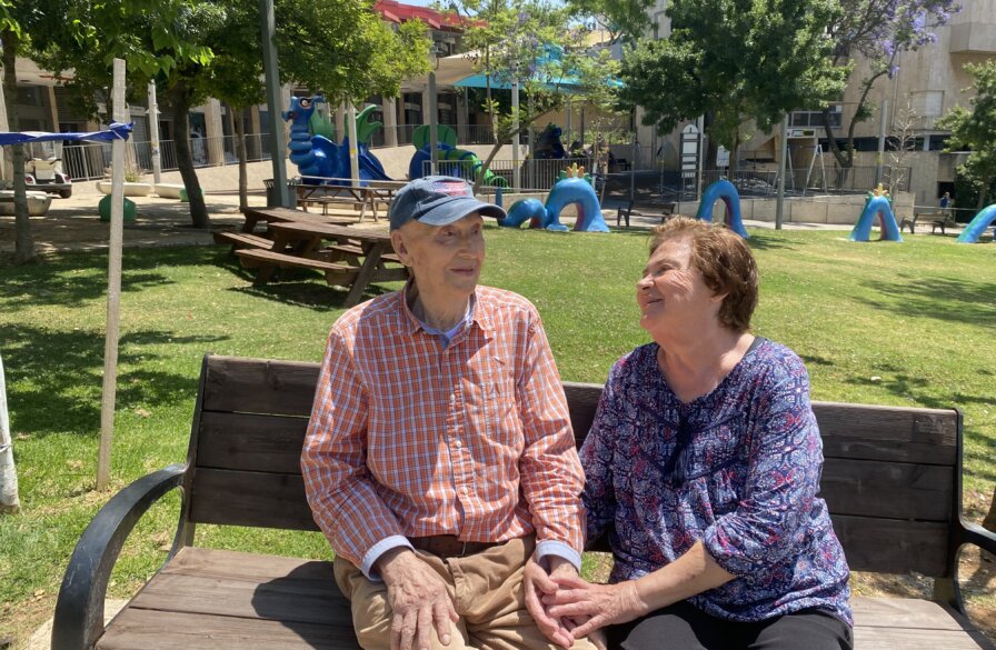 Rafael and Ella sitting at a park bench near their home in Jerusalem.