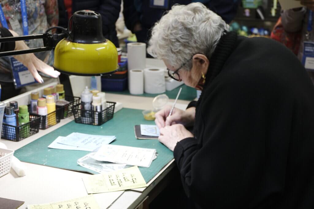 Elderly lady writes on a card